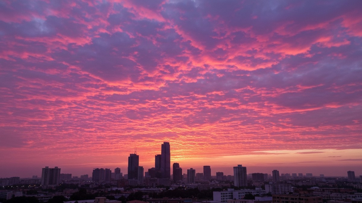 Dramatic pink and purple clouds at dusk over a city skyline