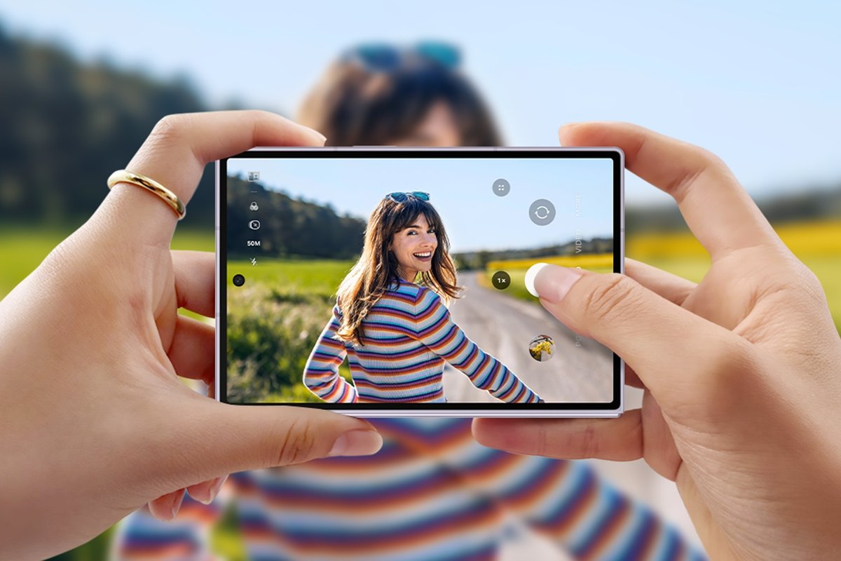 Hands holding the new wider Galaxy Z Fold 8 in landscape showing the camera app on its short, wide screen