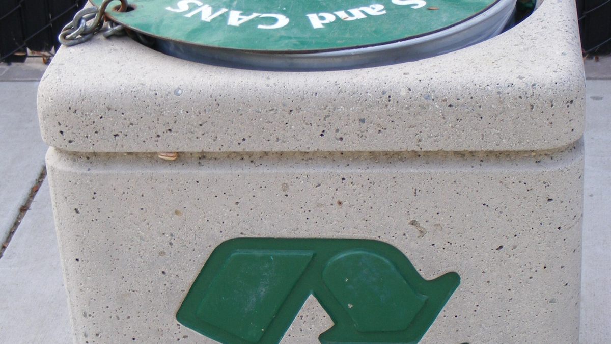 A recycling bin labeled for bottles and cans, whose sugary fermenting residue breeds fruit flies