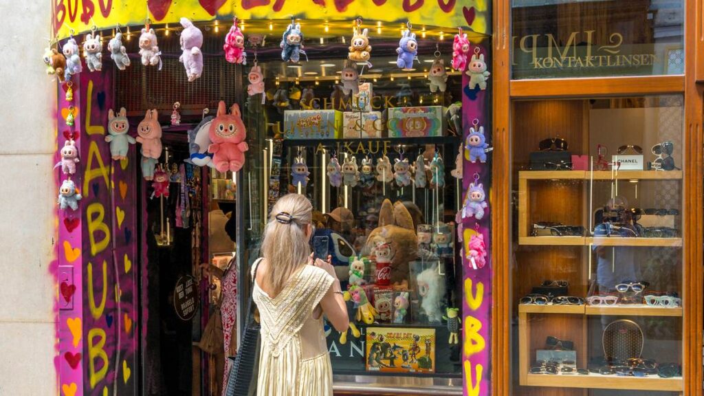 Souvenir shop covered in Labubu graffiti with dozens of Labubu-style plush pendants hanging around the entrance