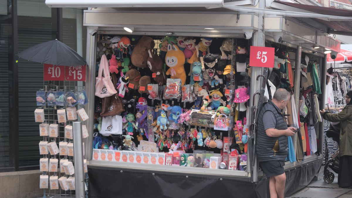 UK market stall selling cheap plush toys including Labubu lookalikes with a five pound price sign