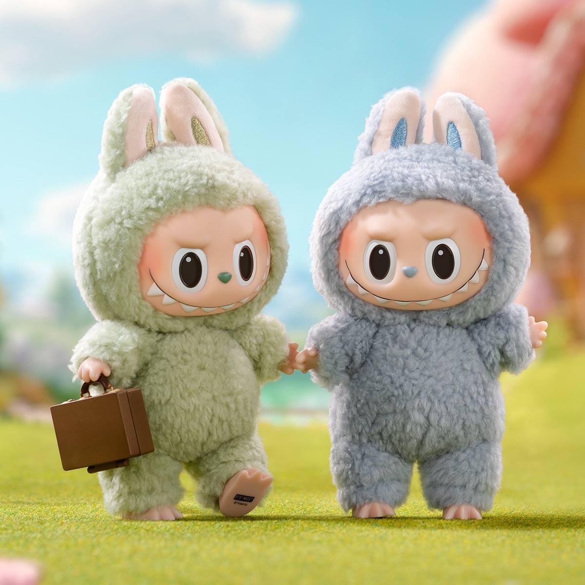Two official vinyl face Labubu plush figures with nine-teeth grins, tall ears and a POP MART stamp visible on one raised foot