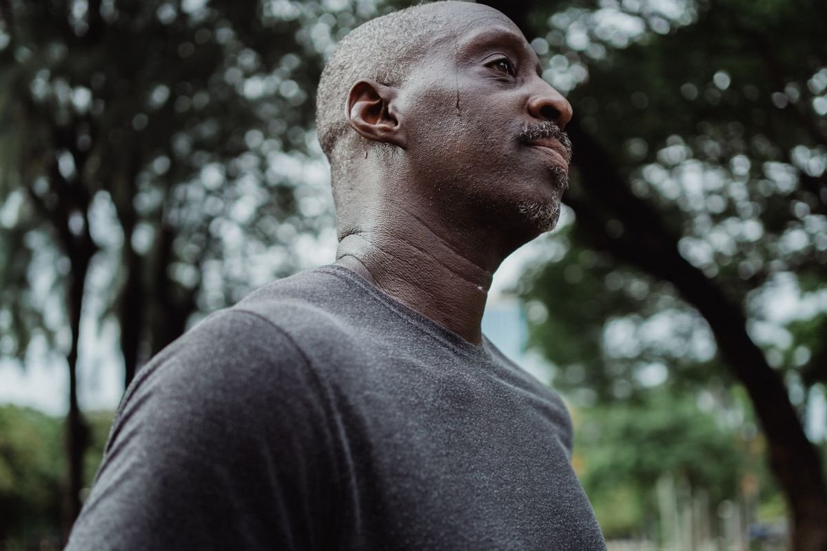 Man outdoors on a hot, muggy day with visible sweat on his neck and face