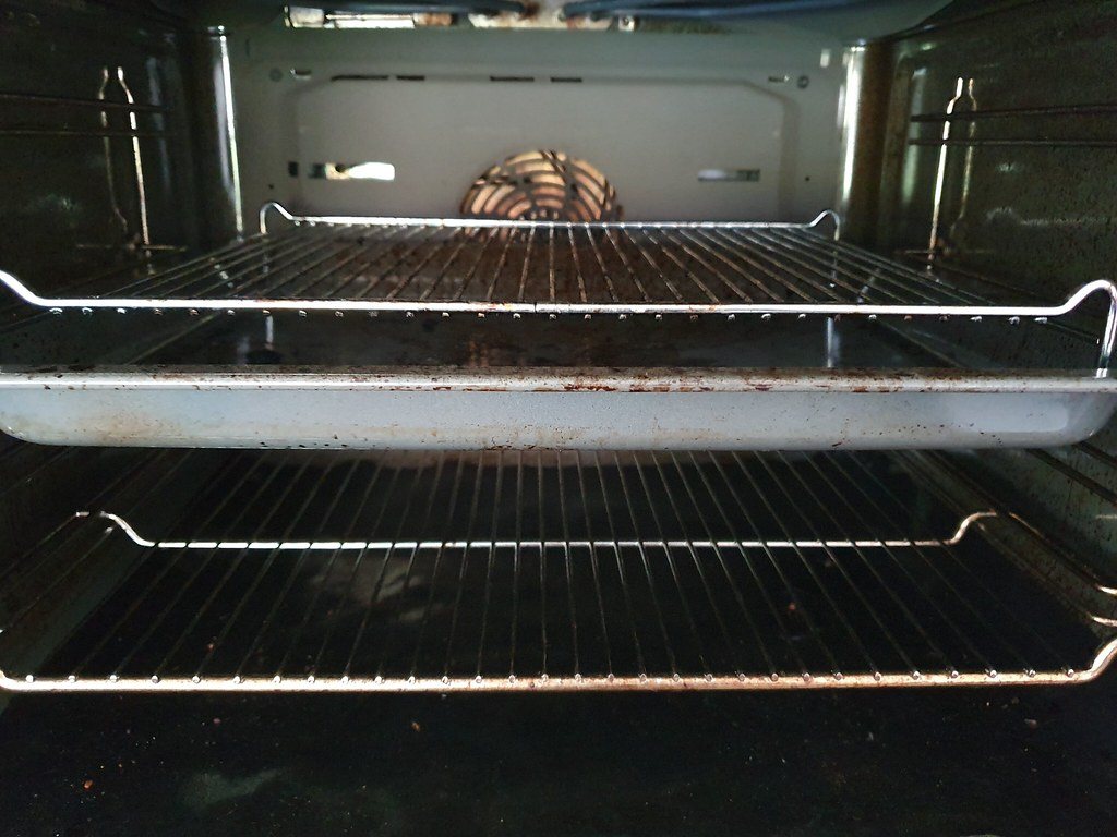 The clean interior of an oven with clear racks and a baking tray, the fresh state that a few small habits keep it in