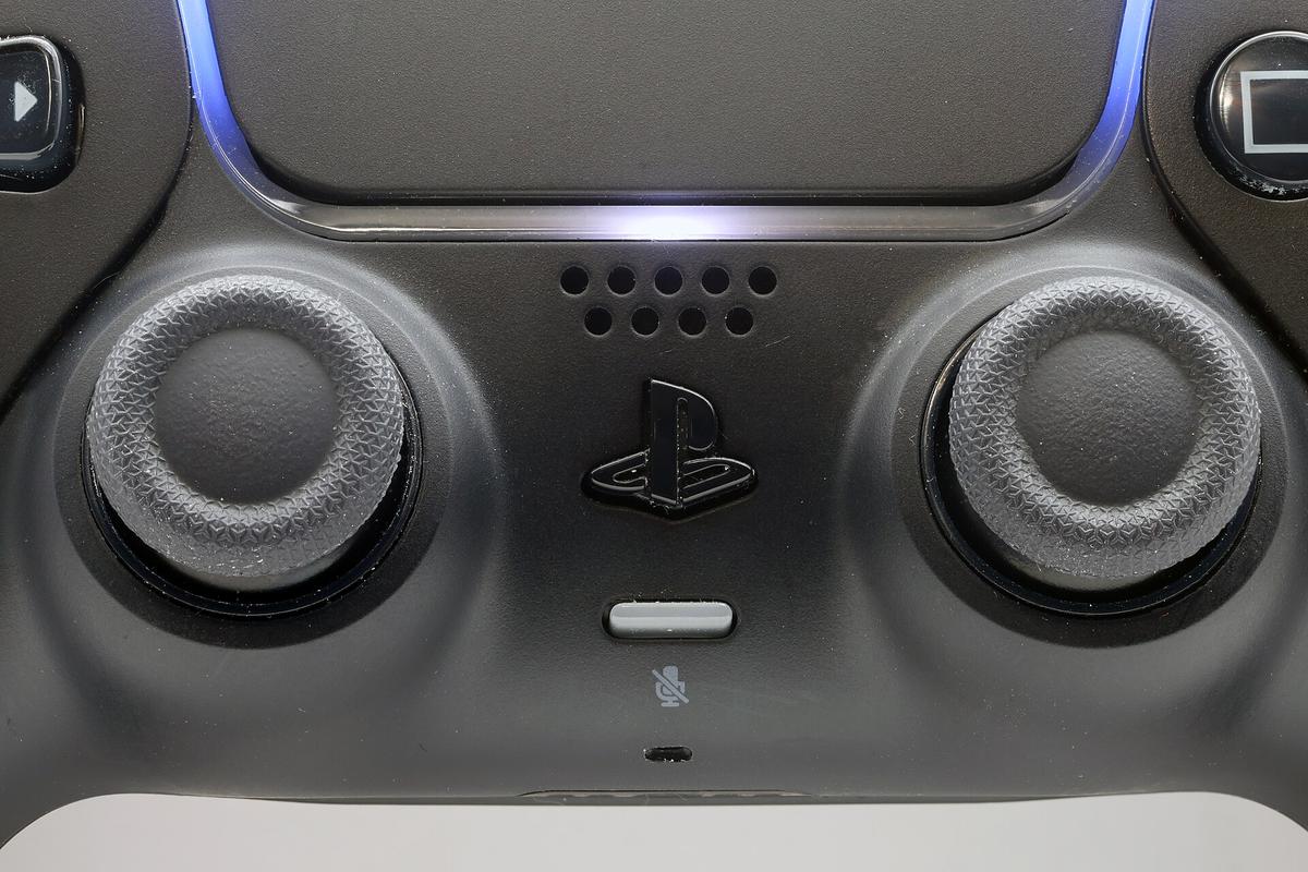 Close-up of the two analog sticks on a black DualSense controller, the exact parts where the drift-causing potentiometer wears down