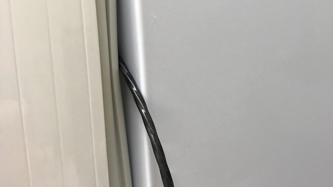 Close-up of the black rubber door gasket running down the seam of a refrigerator door, a hidden spot where mildew grows