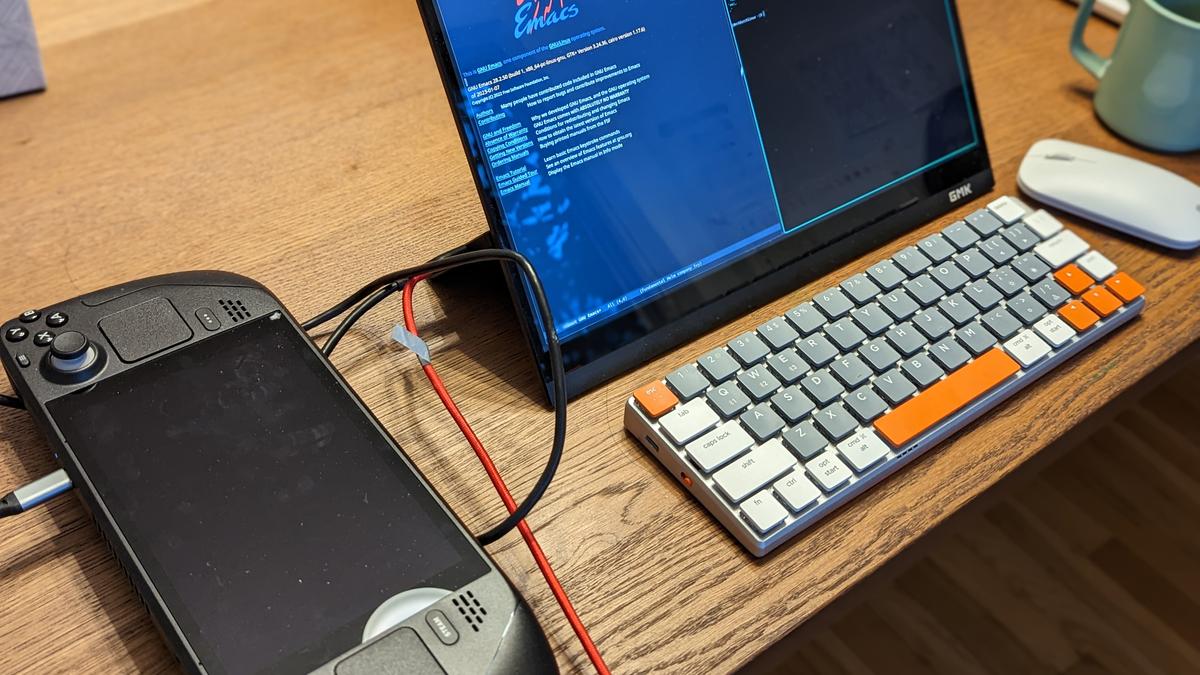 A Steam Deck with a dark screen connected by USB-C to an external portable monitor and keyboard