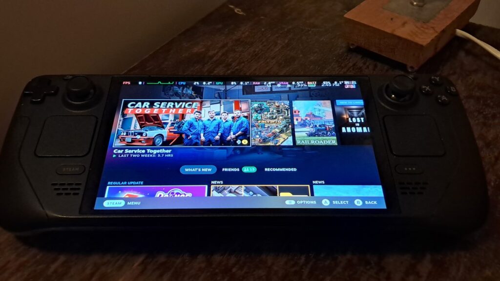A real Valve Steam Deck OLED lying on a desk with the SteamOS home screen on